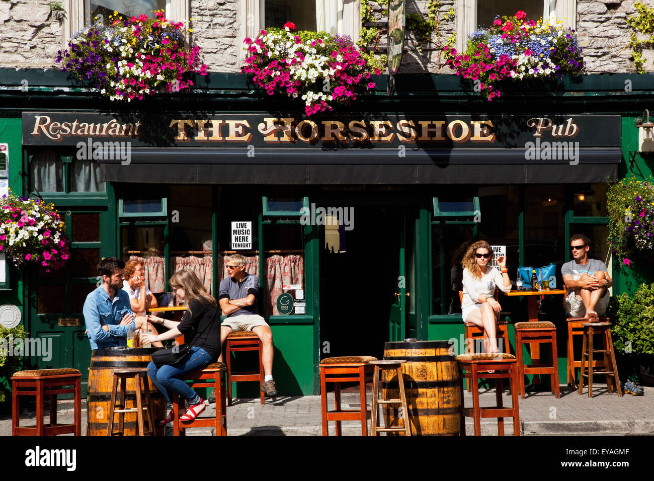 Les clients assis à l'extérieur d'un pub, Kenmare, comté de Kerry, Irlande Banque D'Images
