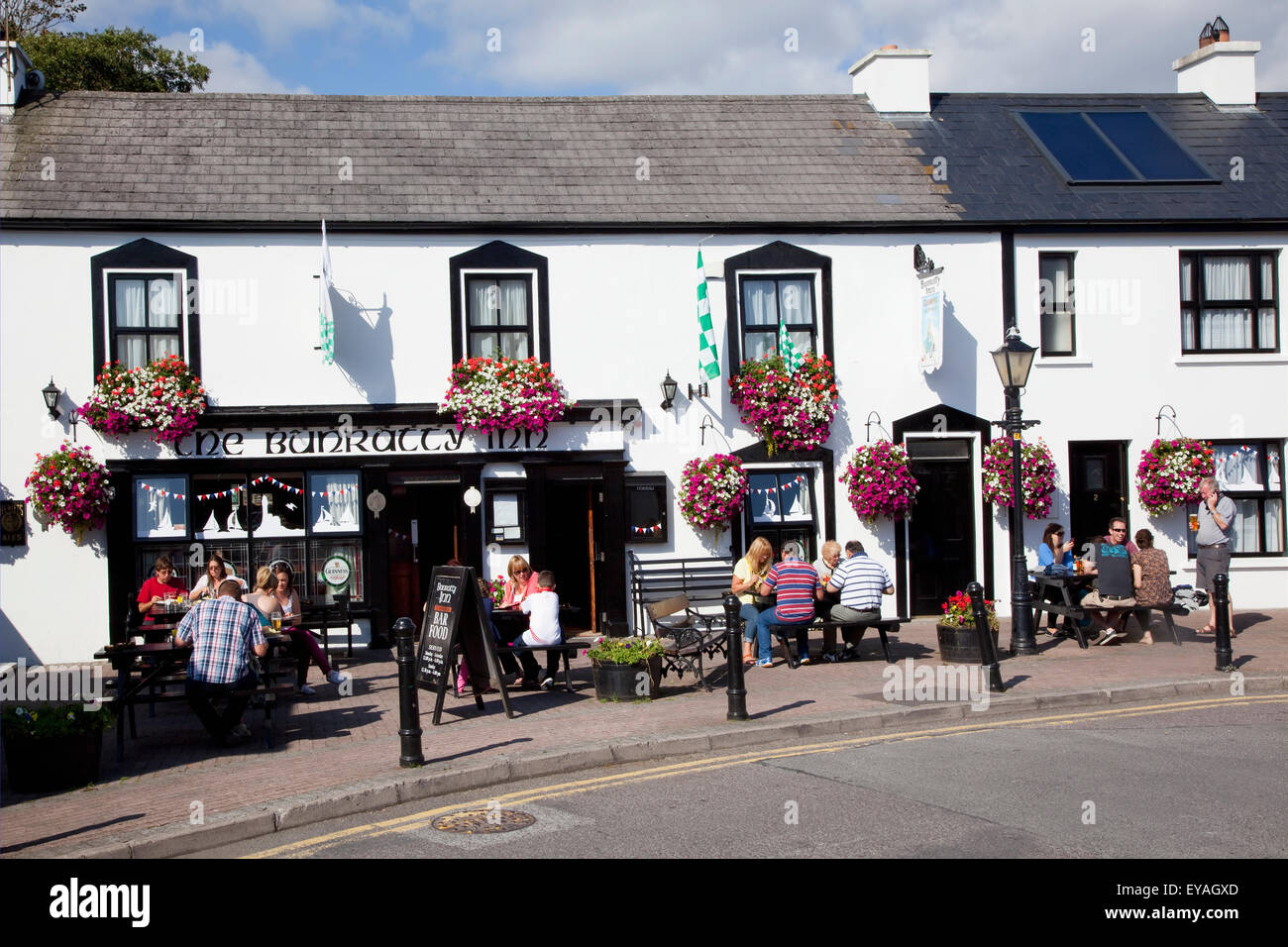 Les clients assis sur la terrasse extérieure d'une auberge ; Schull, comté de Cork, Irlande Banque D'Images