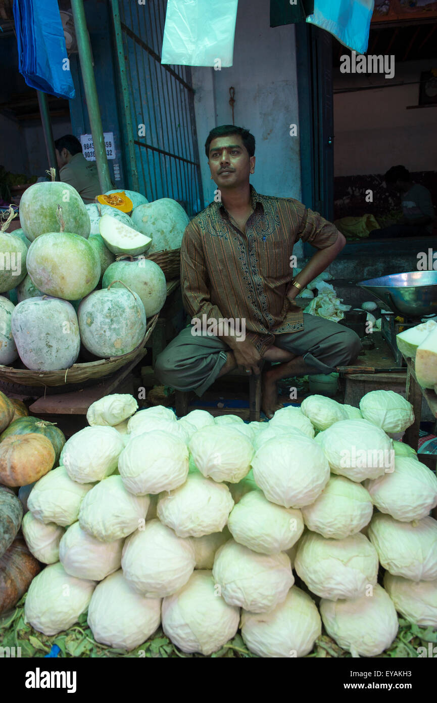 MYSORE, INDE - Novembre 04, 2012 : vendeur indien est assis parmi des piles de légumes frais dans le Devaraja Market. Banque D'Images