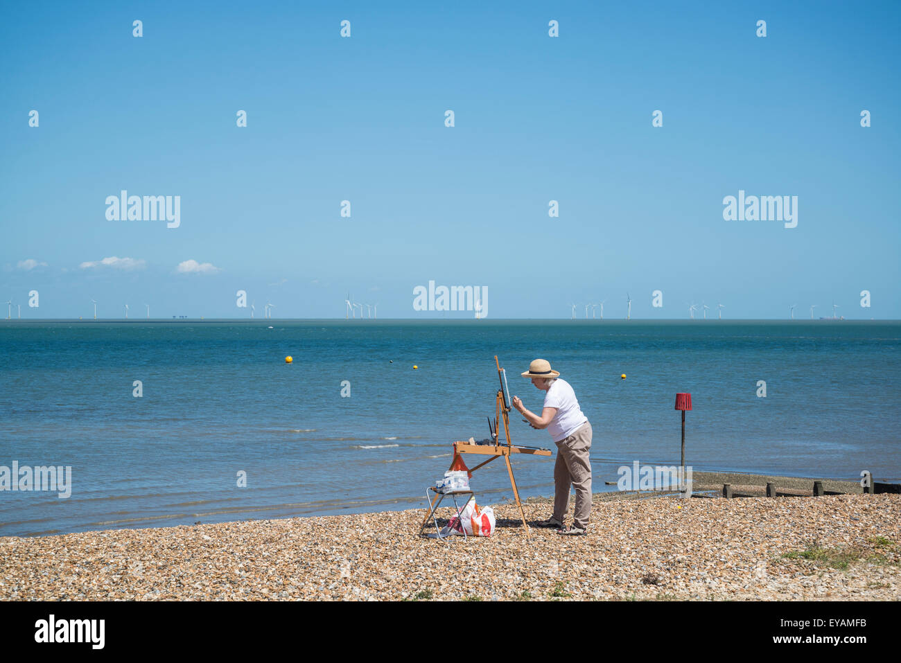 Femme peinture sur la plage, Whitstable, Kent, England, UK Banque D'Images