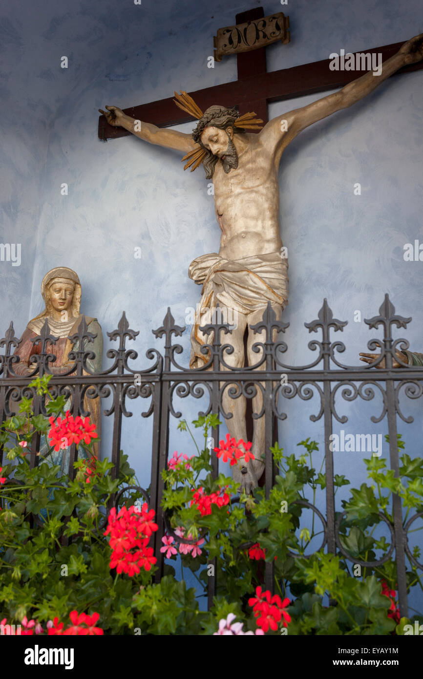 Statue Vierge Marie et Jésus sur la Croix dans la petite chapelle rurale, Cesky Krumlov République tchèque fleurs de Pelargonium Banque D'Images