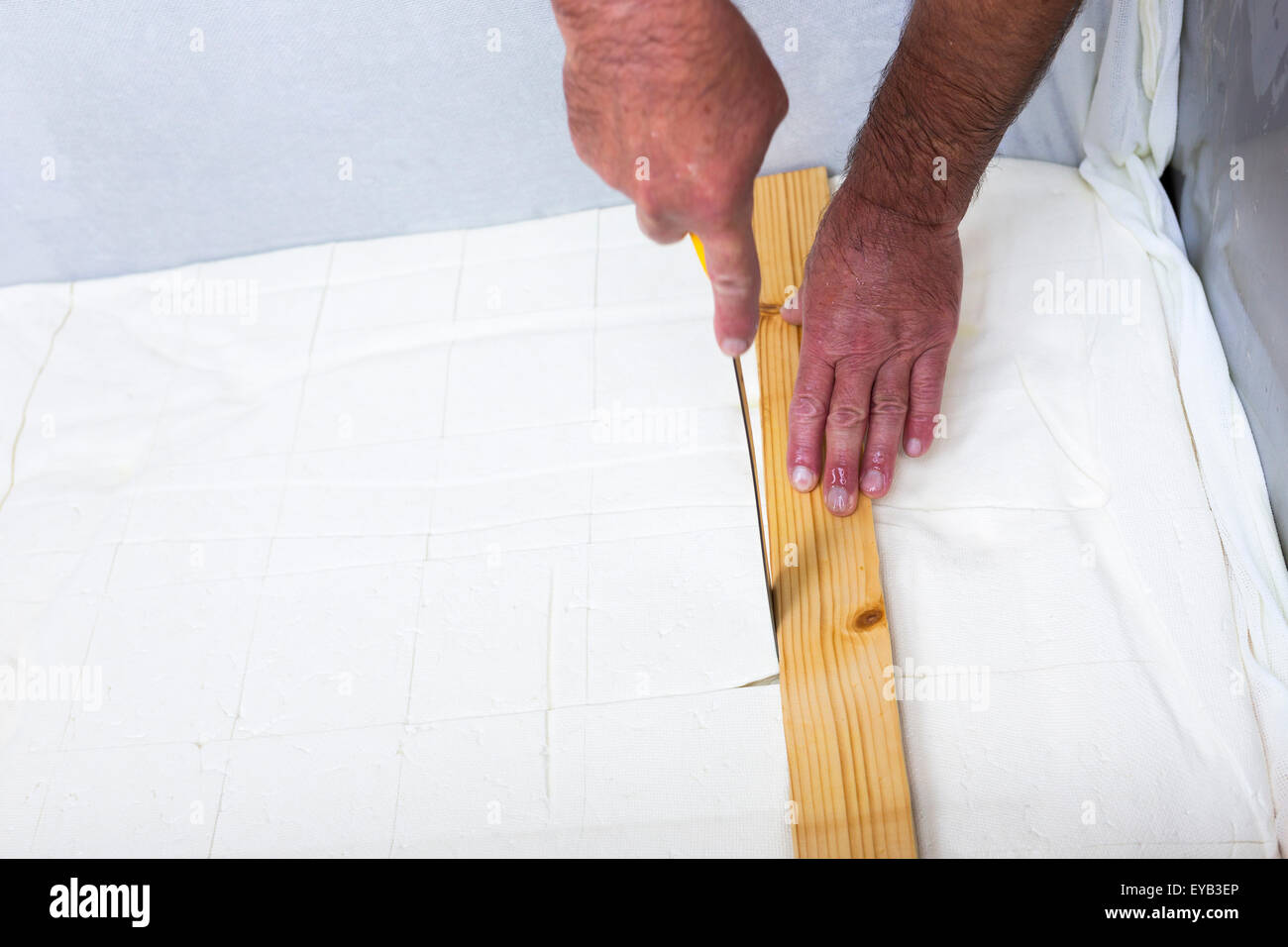 Le processus de production traditionnel blanc savoureux fromage feta bulgare lors de sa dernière étape avant packeting. Couper en cubes avec un Banque D'Images