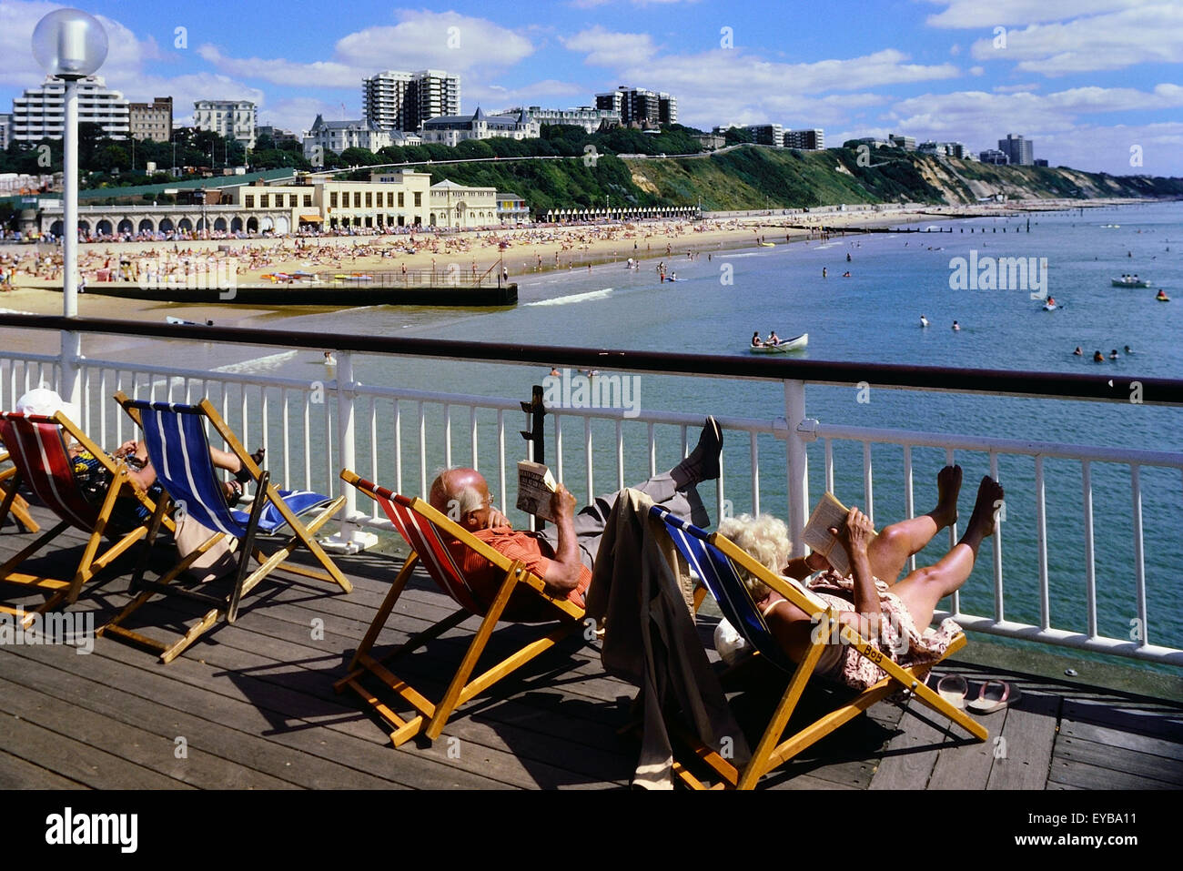 Le soleil dans des chaises longues sur la jetée de Bournemouth. Le Dorset. L'Angleterre. UK Banque D'Images