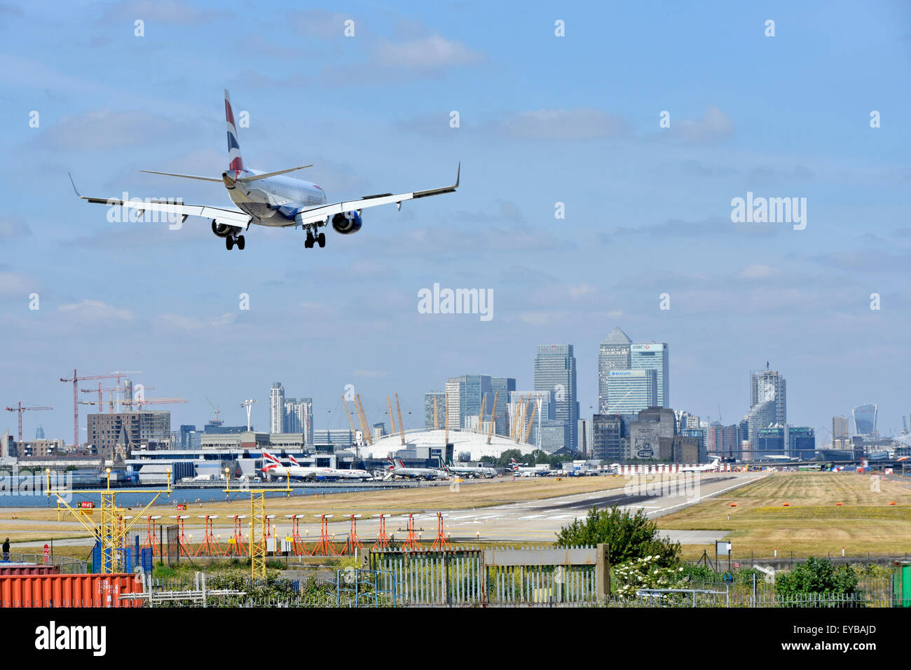 Avion de British Airways à l'atterrissage de l'aéroport de London City Newham avec O2 arena et Canary Wharf à Londres Docklands au-delà de l'horizon à Tower Hamlets England UK Banque D'Images