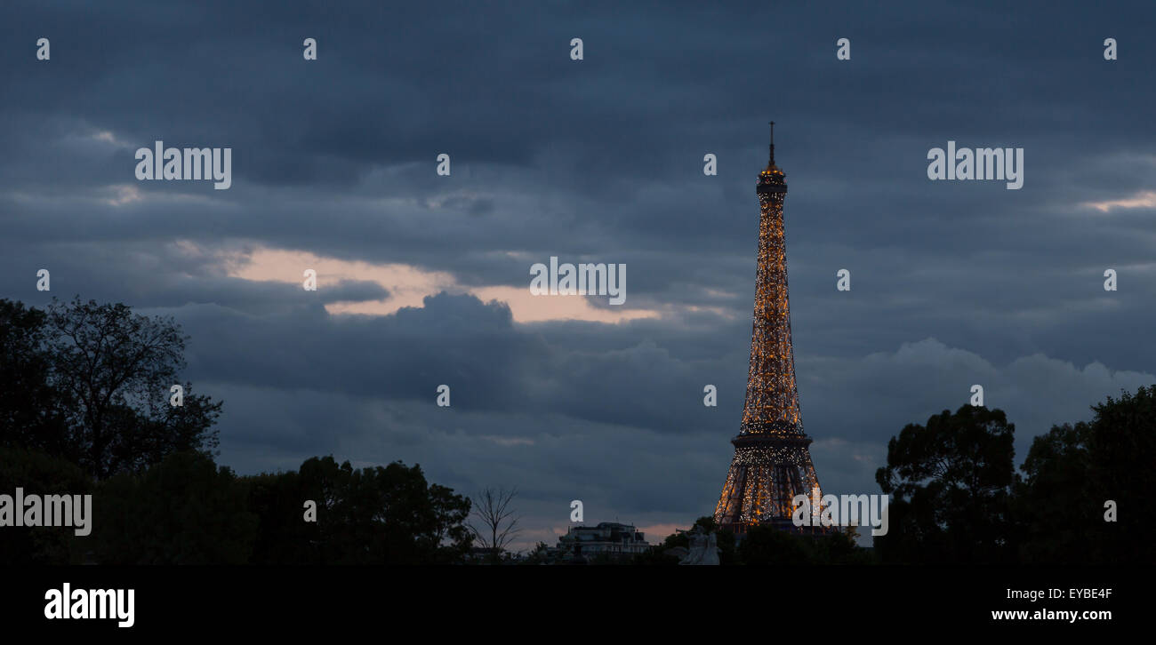 La Tour Eiffel à Paris, France Sparkeling de nuit avec des nuages derrière lui. Banque D'Images