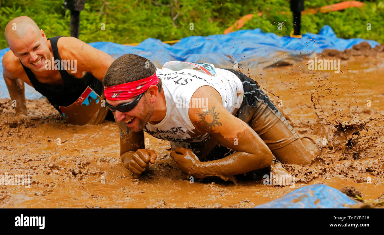 Mark Small (à gauche) et Danny Gahan ramper dans un trou au niveau de la boue Mud Run pour coeur 25 juillet 2015, Waterford, Nouveau-Brunswick, peut Banque D'Images