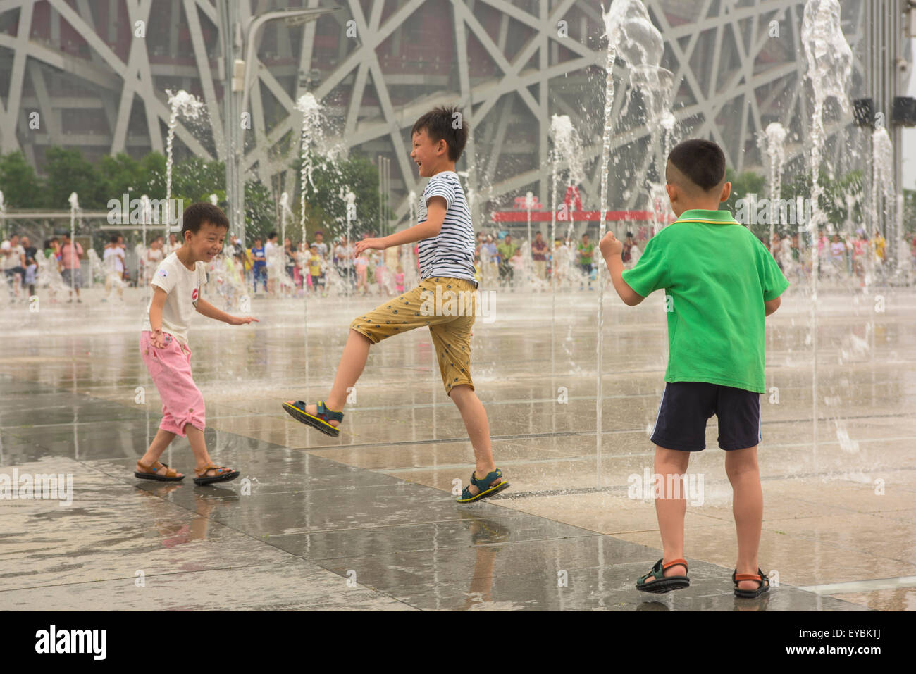 Parmi les enfants chinois à l'aspersion d'eau devant le nid d'Oiseau Stadium, Beijing, juillet 2015 Banque D'Images