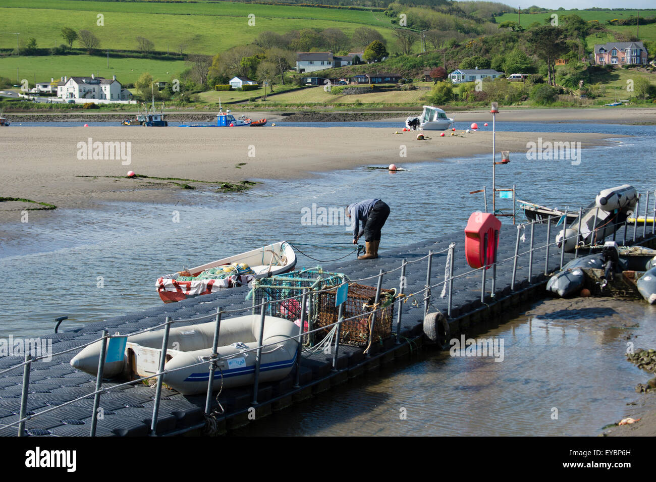 Un pêcheur debout sur le ponton d'amarrage à Gwbert sur l'estuaire de la rivière Teifi Tivy Ceredigion, pays de Galles UK Banque D'Images