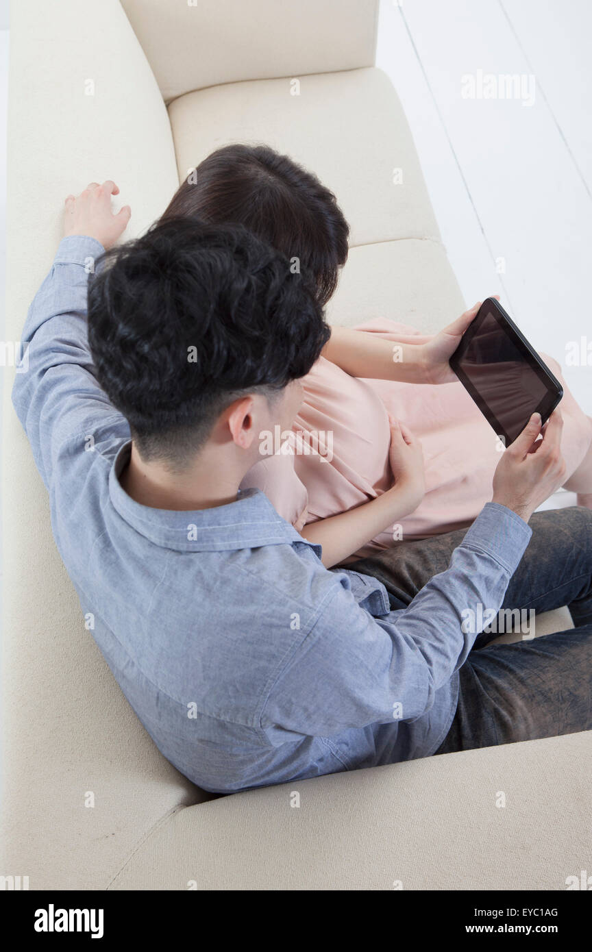 Jeune homme et femme enceinte tenant une tablette numérique, Banque D'Images