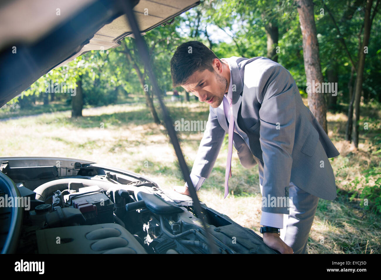 Homme regardant sous le capot de la voiture Banque de photographies et ...