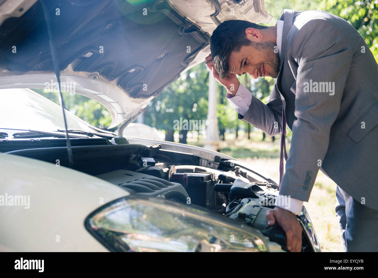 Homme regardant sous le capot de la voiture Banque de photographies et ...