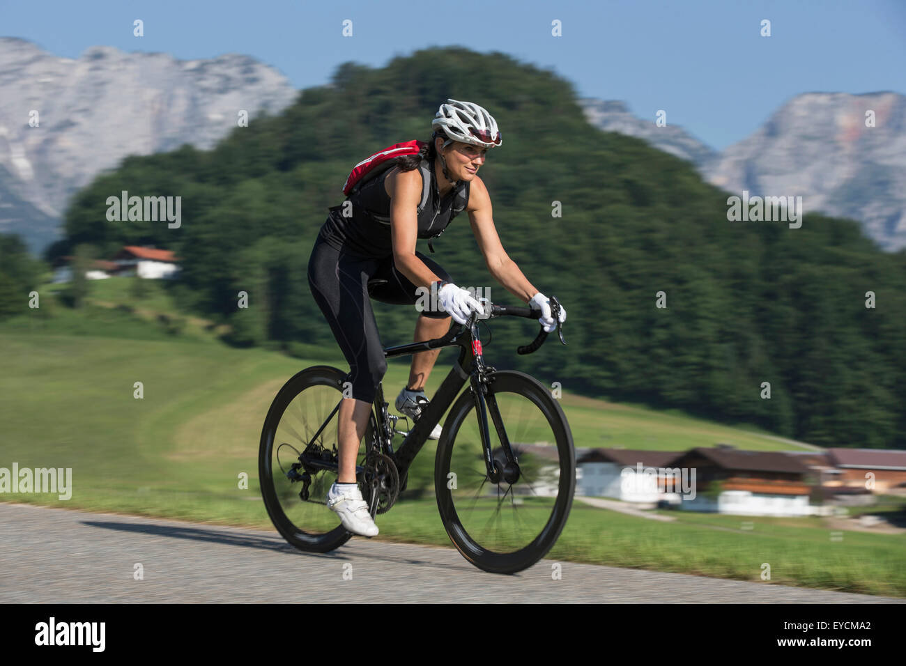 Allemagne, Bad Reichenhall, sportive woman riding bicycle Banque D'Images