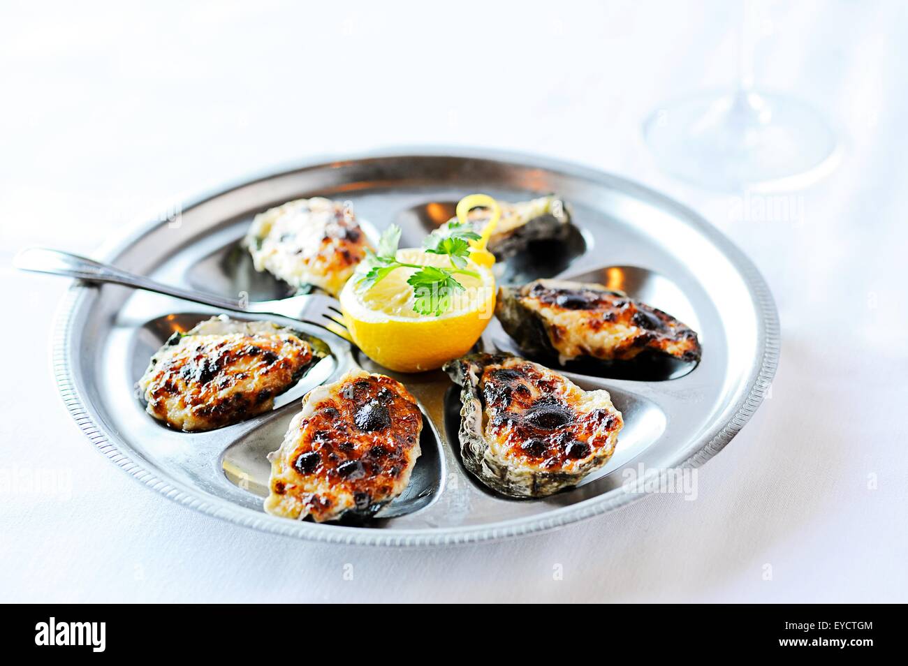 Huîtres au barbecue avec du citron sur la table de restaurant Banque D'Images