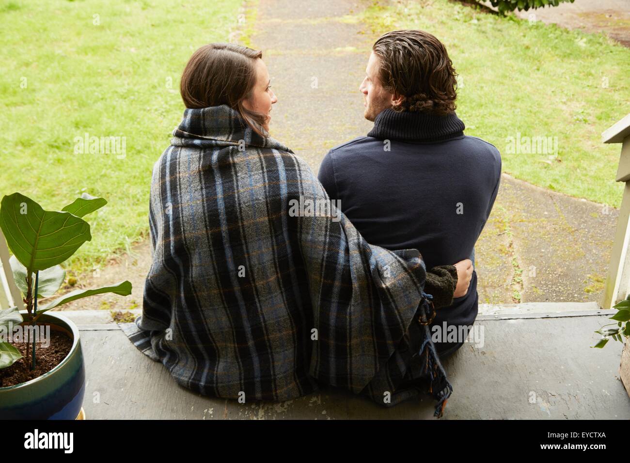 Vue arrière du jeune couple assis sur le porche l'étape Banque D'Images