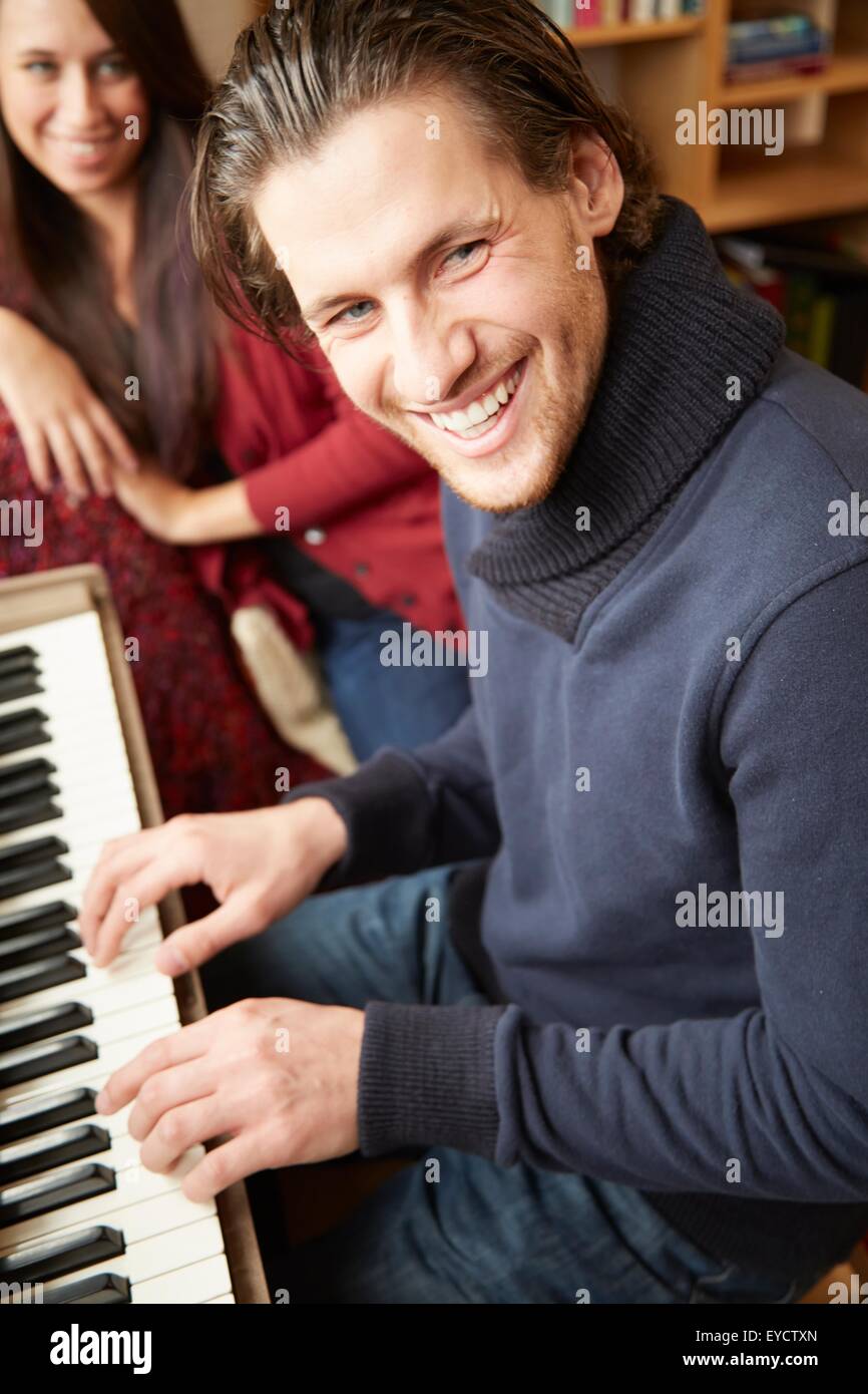 Portrait de jeune homme jouant du piano pour l'amie Banque D'Images