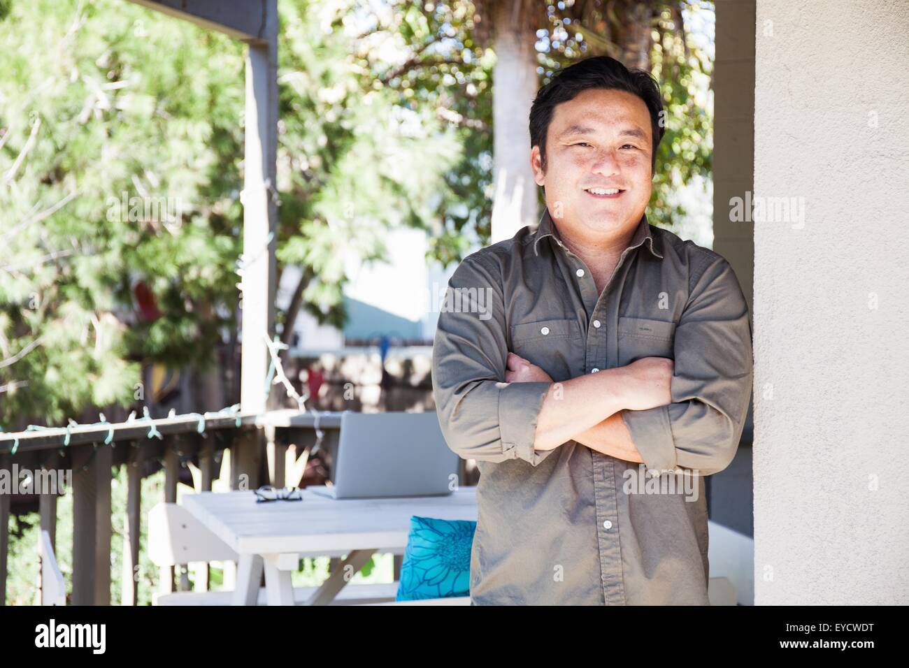 Portrait of man with arms folded on porch Banque D'Images