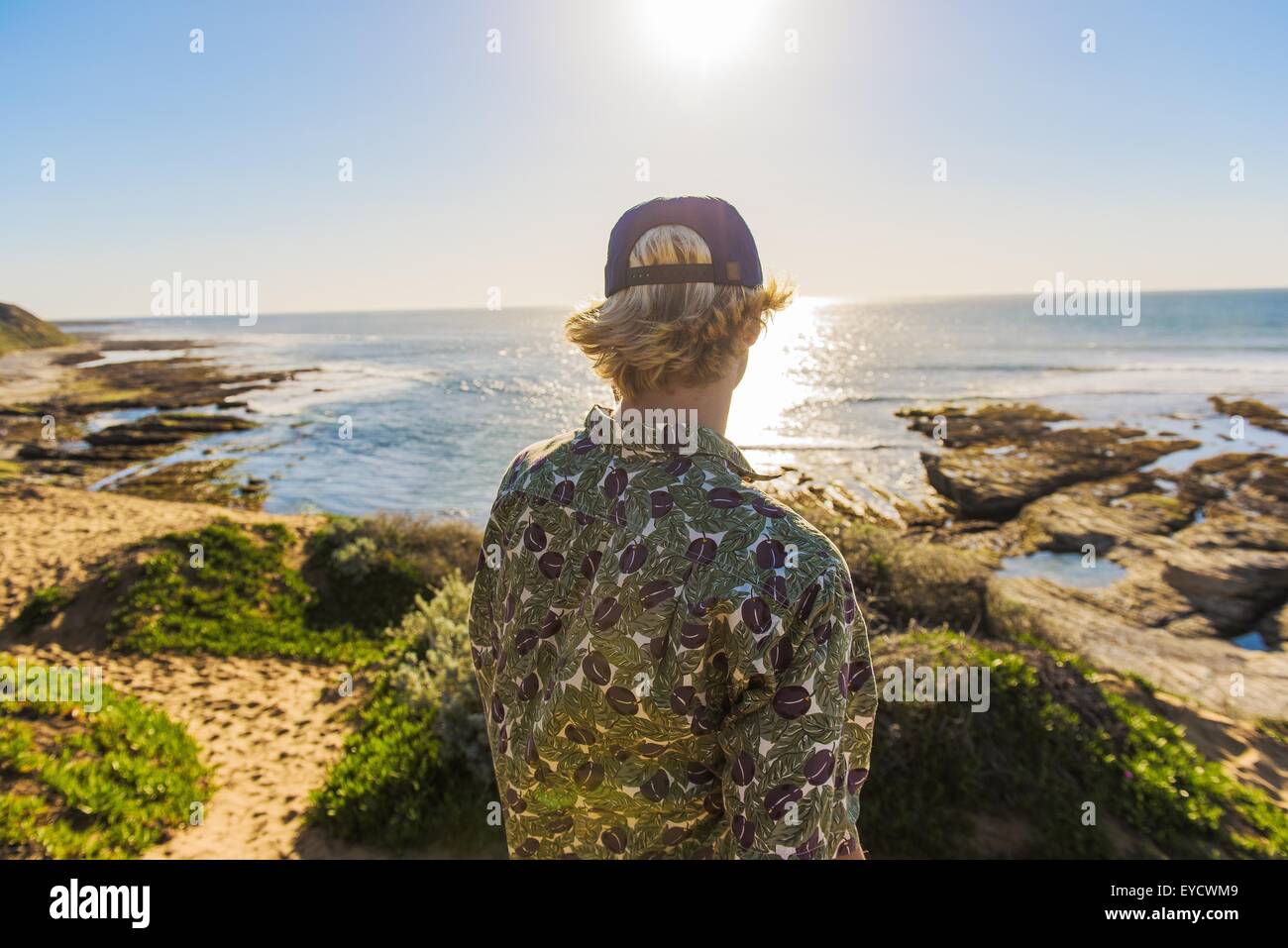 Jeune homme debout, regardant l'océan, vue arrière Banque D'Images