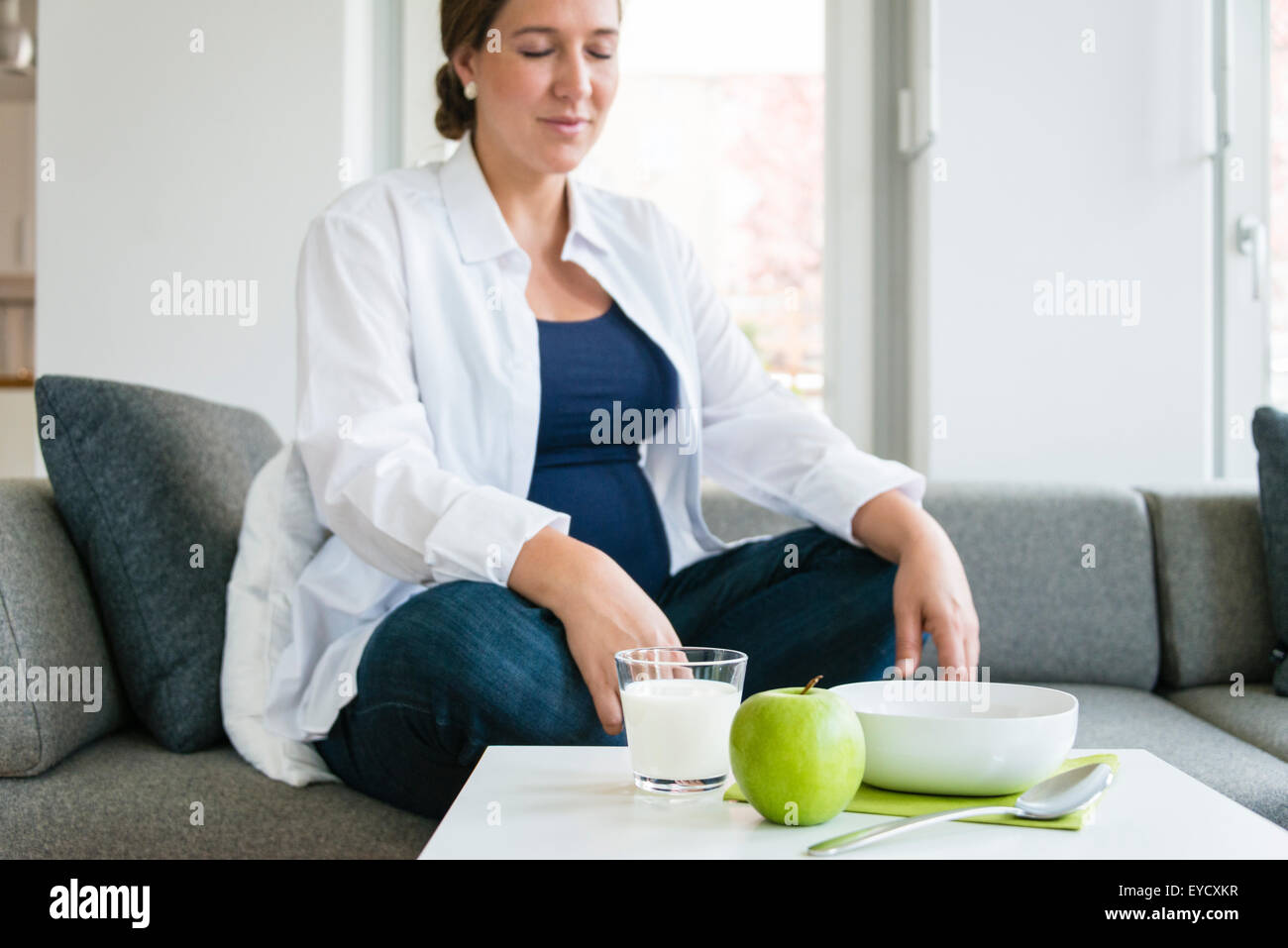 Pregnant woman relaxing in living room Banque D'Images