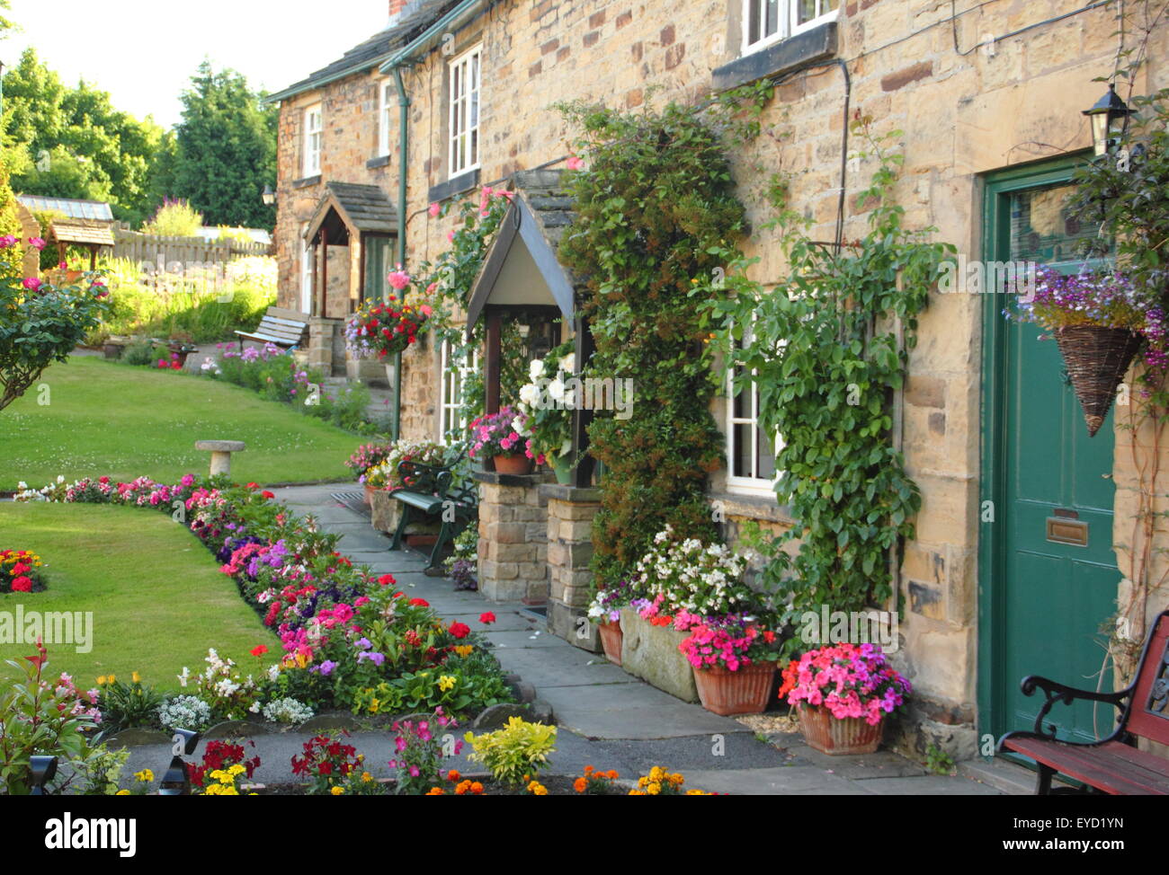 Construit en pierre traditionnelle britannique chalets avec jardin immaculé dans une succession de frontières English Village, South Yorkshire, Angleterre, Royaume-Uni Banque D'Images