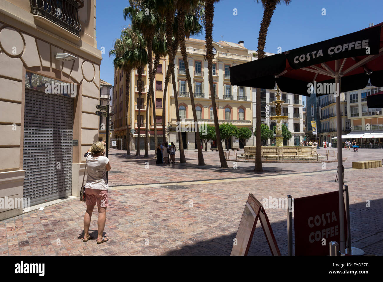 Un touriste prend une photo dans la Plaza de la Constitución à Malaga, Andalousie, Espagne Banque D'Images
