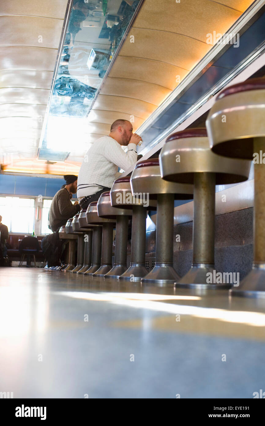 Usa, l'État de New York, New York City, Brooklyn, les hommes de manger à manger des Cheeseburgers Relish ; Williamsburg Banque D'Images