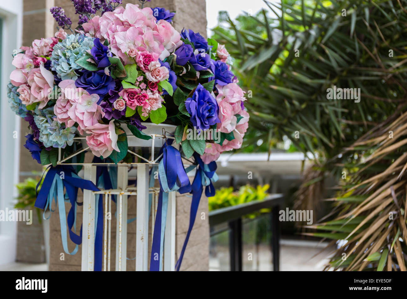 Bouquet de fleurs artificielles colorées en face de la maison. Banque D'Images