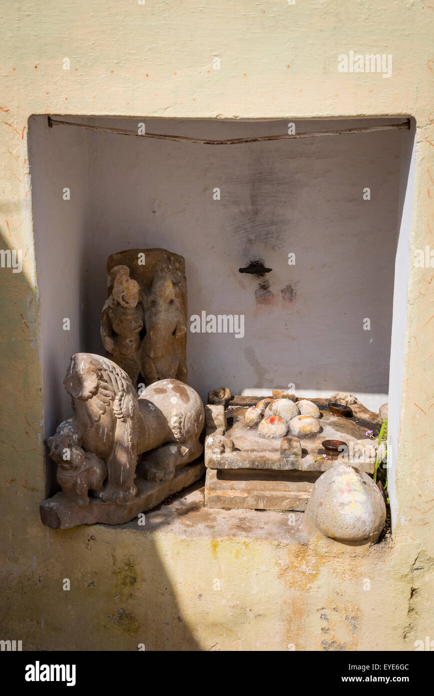 Petit sanctuaire hindou incorporant d'anciennes pièces de sculptures du temple dans l'ancien village de Khajuraho, Madhya Pradesh, Inde Banque D'Images