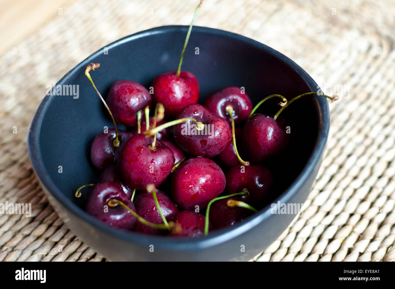 Bol de cerises douces dans un bol noir. Banque D'Images