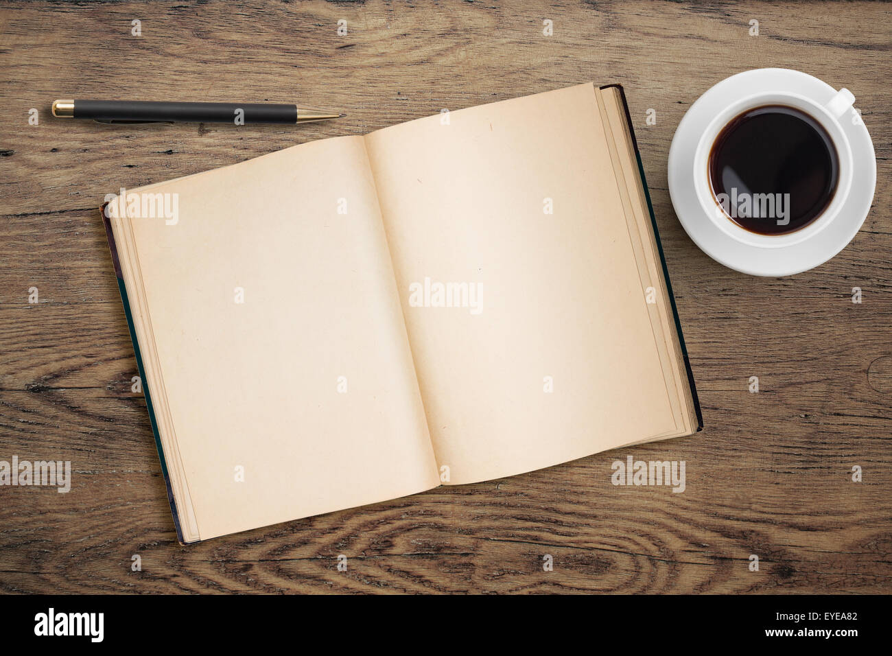 Journal ouvert avec stylet et tasse à café sur table en bois ancien Banque D'Images