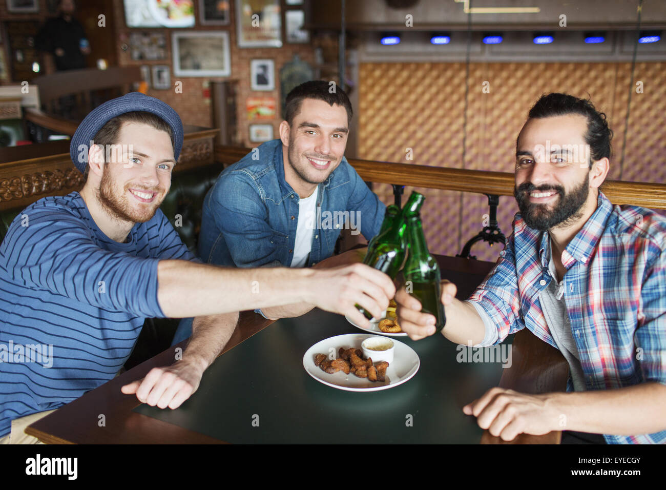 Heureux amis boire une bière au bar ou au pub Banque D'Images