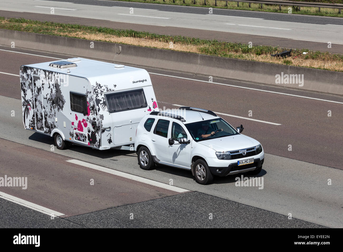 Dacia Duster avec une caravane qui passe njoy la lumière du soleil sur l'autoroute Banque D'Images