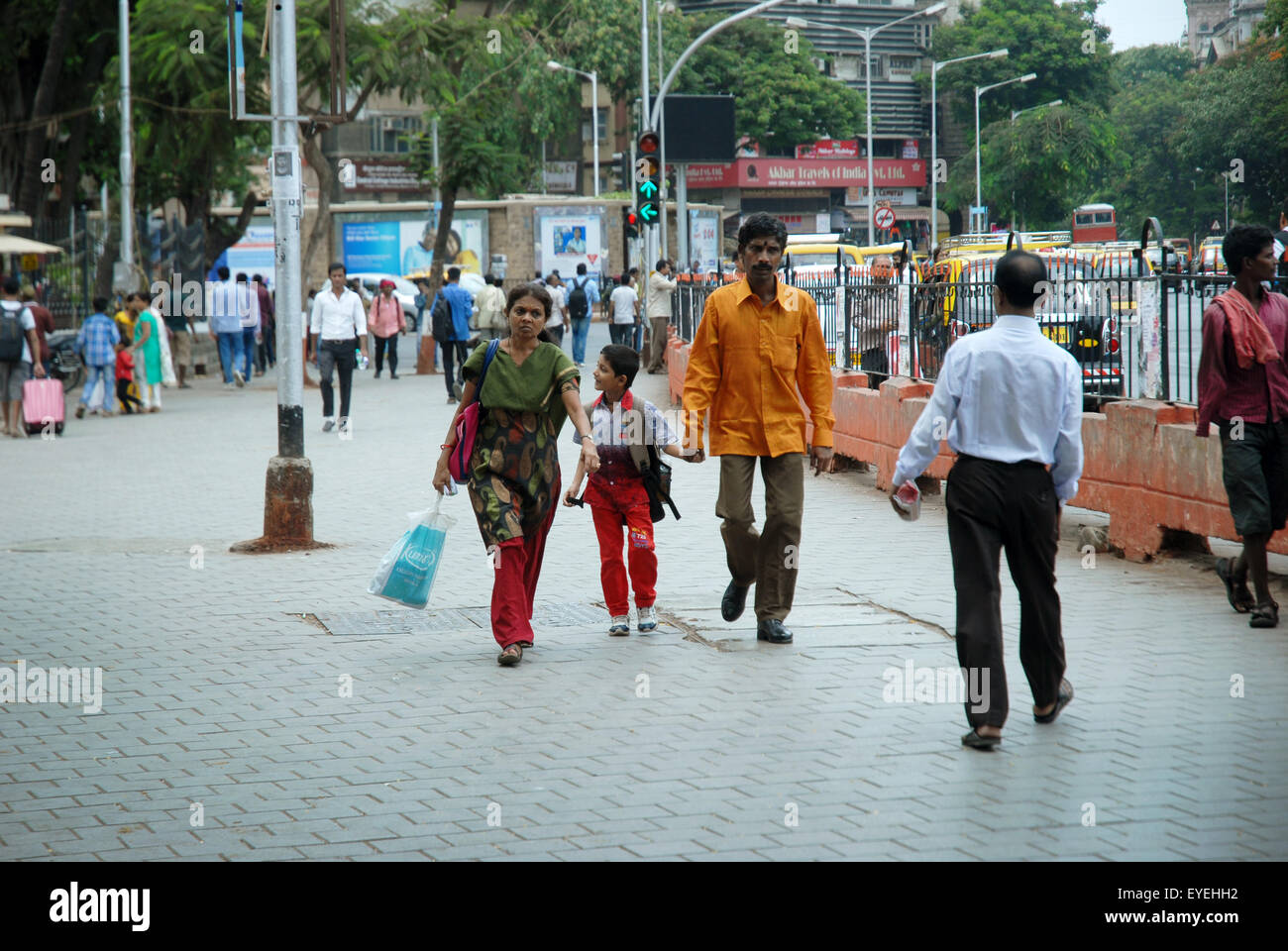 Jeune famille marchant dans la rue, Mumbai, Maharashtra, Inde. Banque D'Images