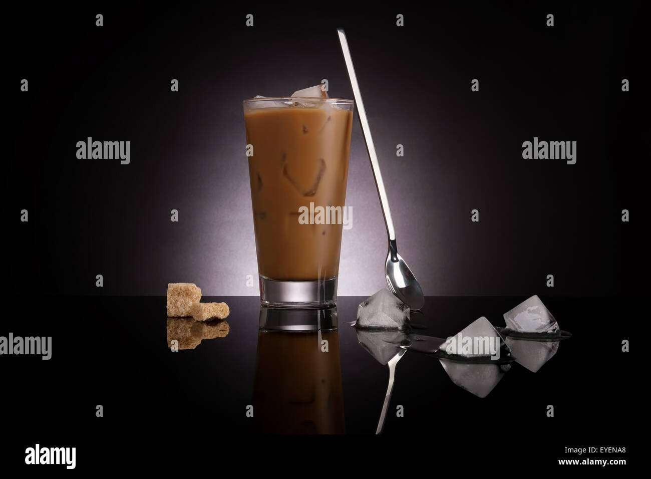 Délicieuse du café avec des cubes de glace fondante et de sucre brun sur fond sombre. La consommation de café de luxe gastronomique culinaire. Banque D'Images