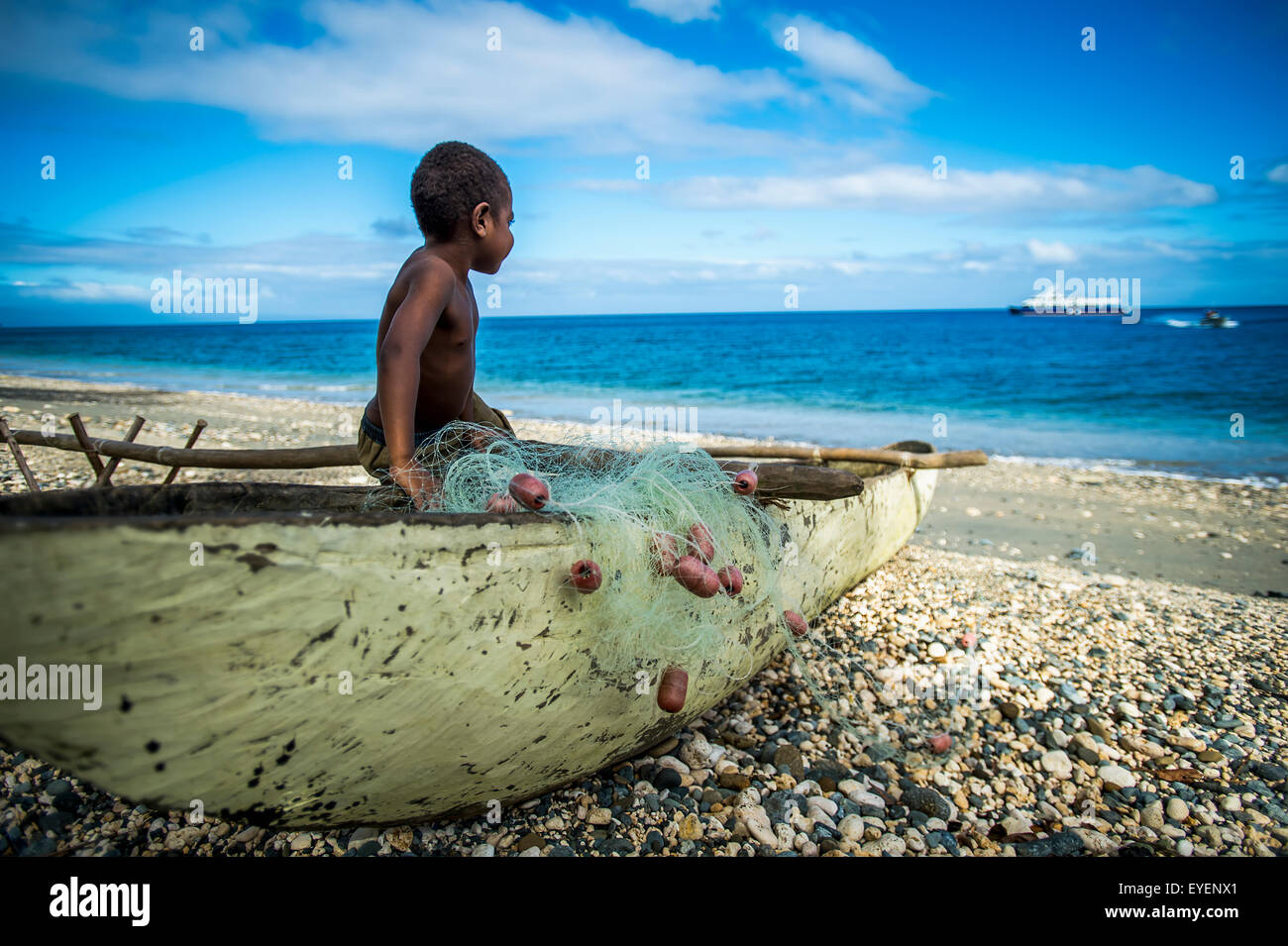 Un jeune garçon regardant un bateau de croisière arriver ; la Pentecôte, l'île de Vanuatu Banque D'Images