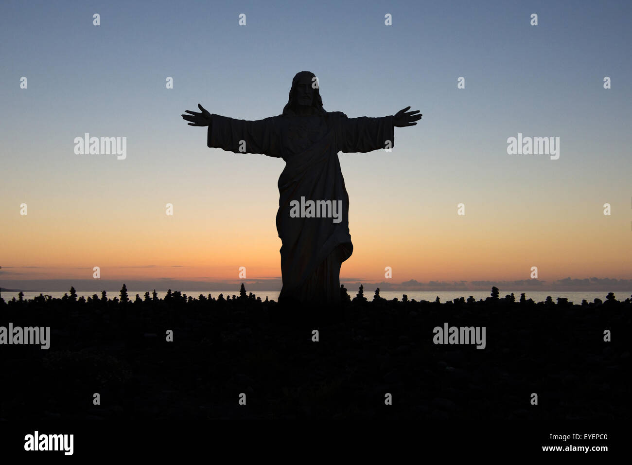 Jésus vous aime - statue sur sunset sky Banque D'Images