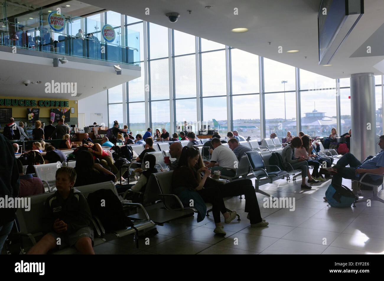 Passagers sont assis dans une zone d'attente à l'intérieur de l'aéroport de Dublin en Irlande. Banque D'Images