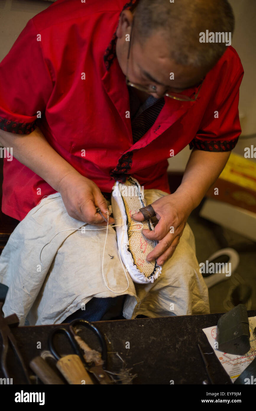 Main dans la fabrication de chaussures magasin de chaussures Neiliansheng, dans Dashilar Street, à Beijing, Chine Banque D'Images