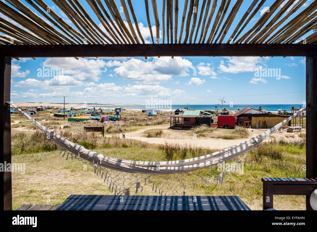 Un hamac est suspendu sous une véranda ombragée avec des bâtiments le long de la côte ; Cabo Polonio, Uruguay Banque D'Images