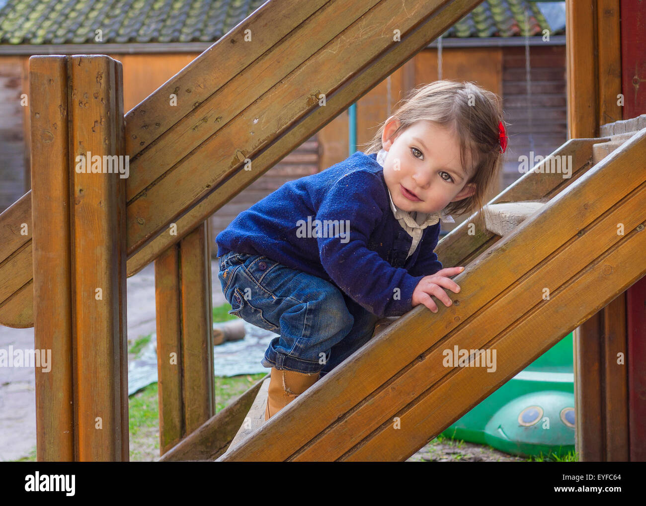 Mignon bébé fille jouant dans l'aire de jeux Banque D'Images