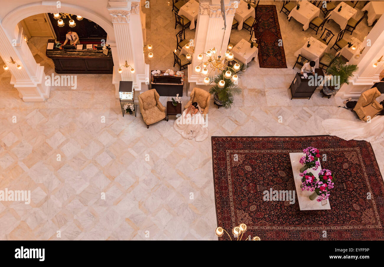 Bride-à-être se trouve dans le hall de l'Hôtel Raffles, attendant d'avoir des photos prises. Banque D'Images