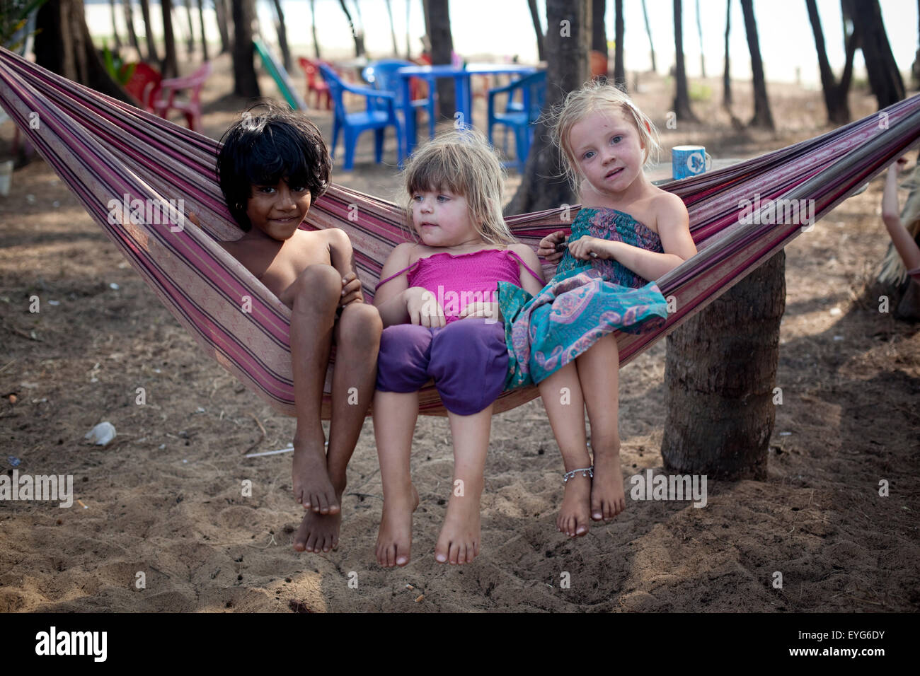 Les enfants britanniques en vacances jouer dans un hamac et faire des amis  avec une fille locale sur Turtle Beach, Goa, Inde Photo Stock - Alamy