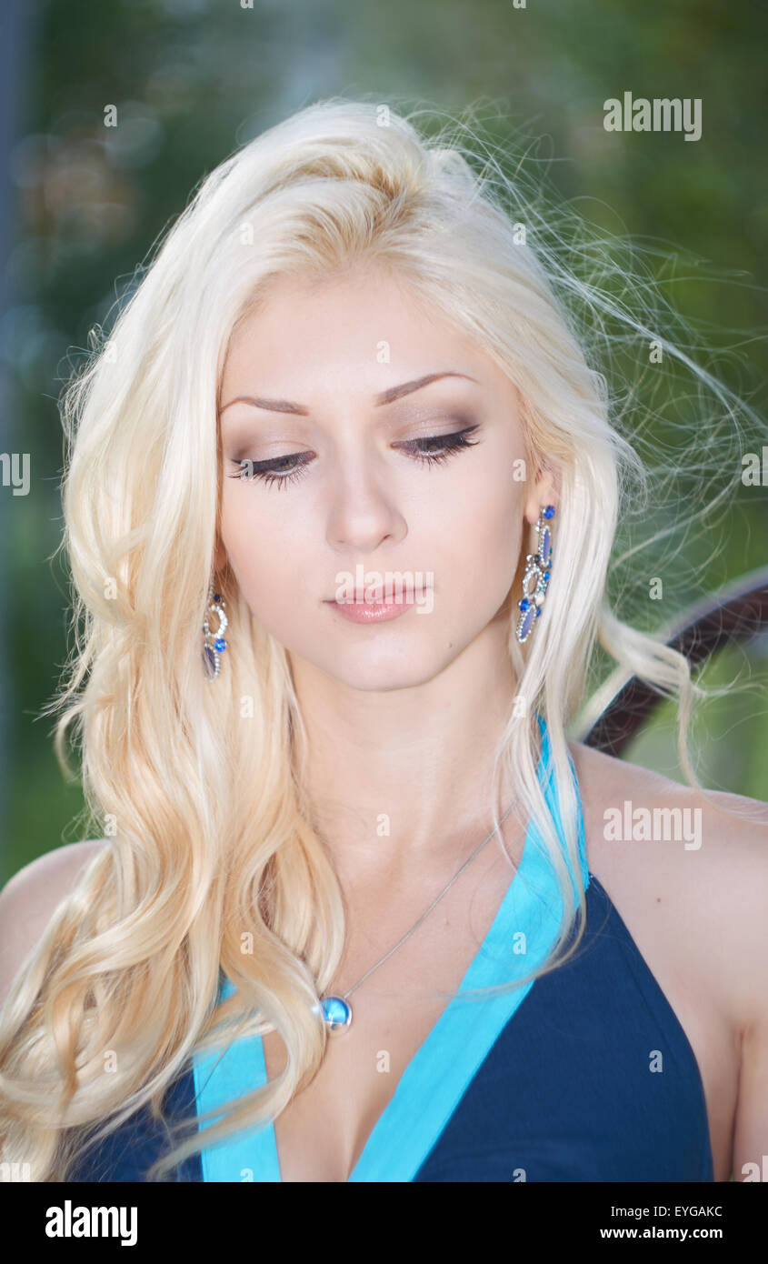 Portrait de la belle fille blonde en robe bleue dans le parc Banque D'Images