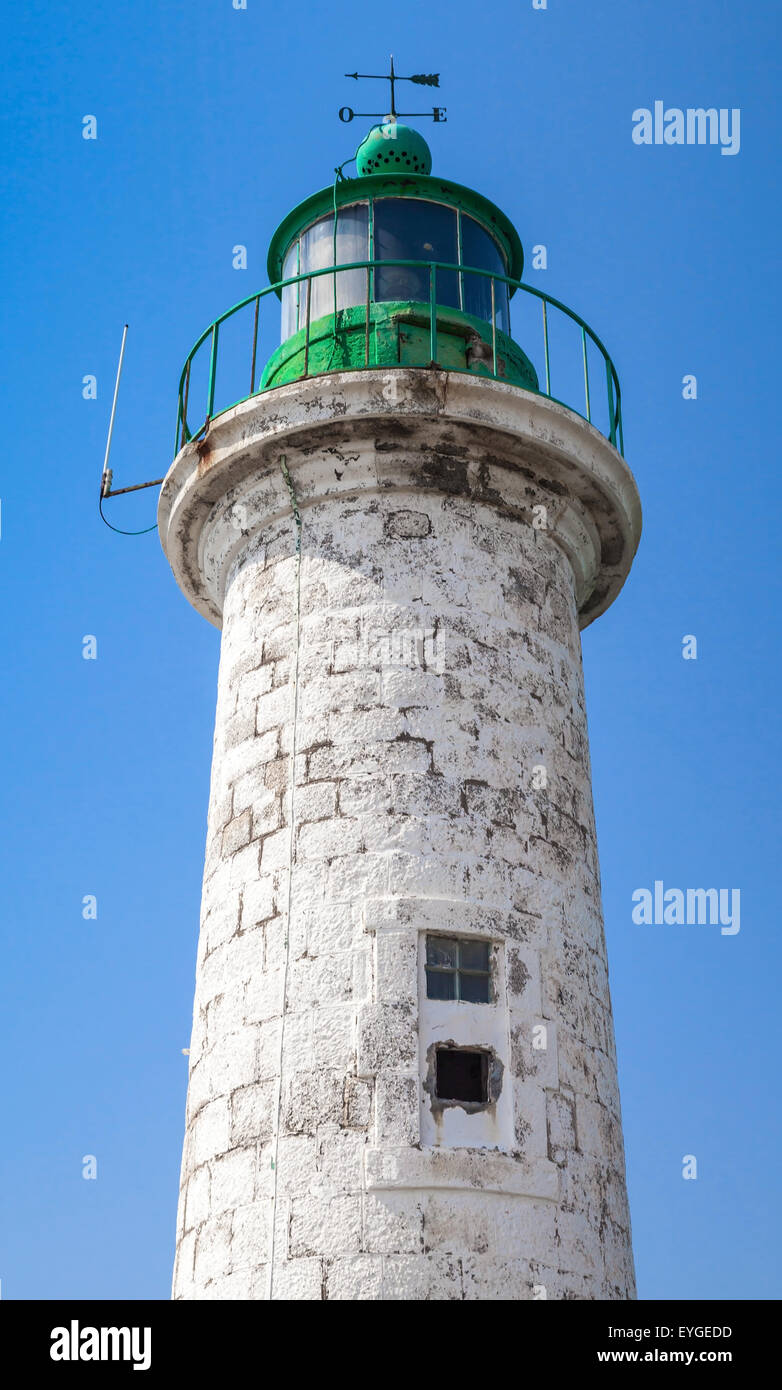 Typique des côtes de la mer Méditerranée vieux phare sur fond de ciel bleu. White tour ronde en pierre avec partie supérieure verte Banque D'Images