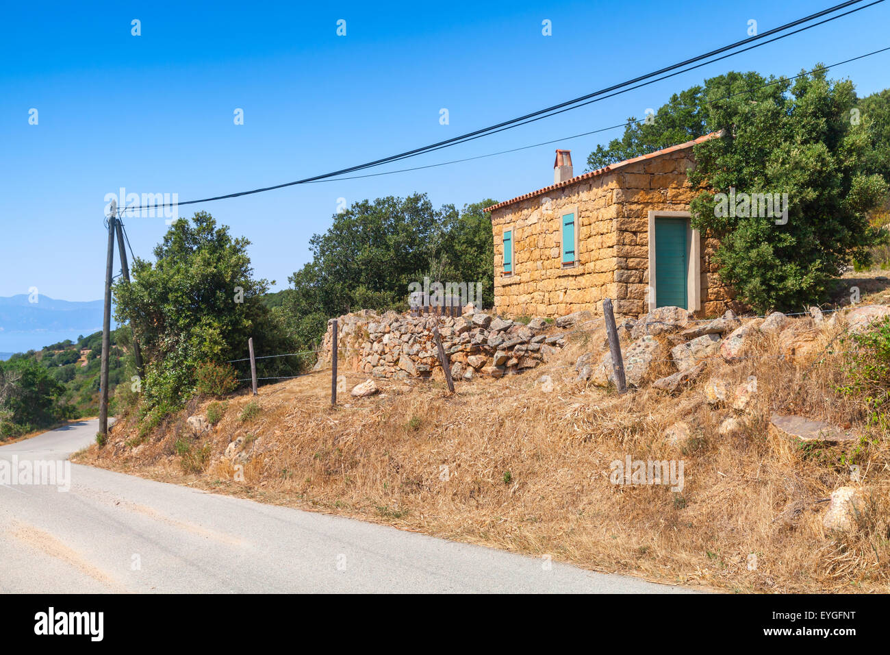 Corse du Sud, paysage rural avec l'ancienne petite maison faite de pierres jaunes sur l'accotement Banque D'Images