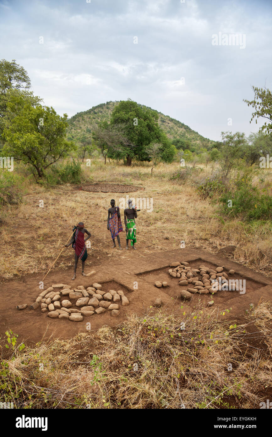 L'Éthiopie, de l'ouest de l'Ethiopie, vallée de l'Omo, dans le sud de l'Mursiland, vue de trois guerriers Mursi sur terrain ; Dirikoro Banque D'Images