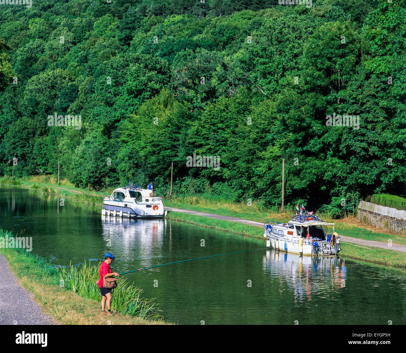 Femme pêche, bateaux de croisière amarrés, canal de Bourgogne, de la vallée de l'Ouche, Côte-d'Or, France, Europe Banque D'Images