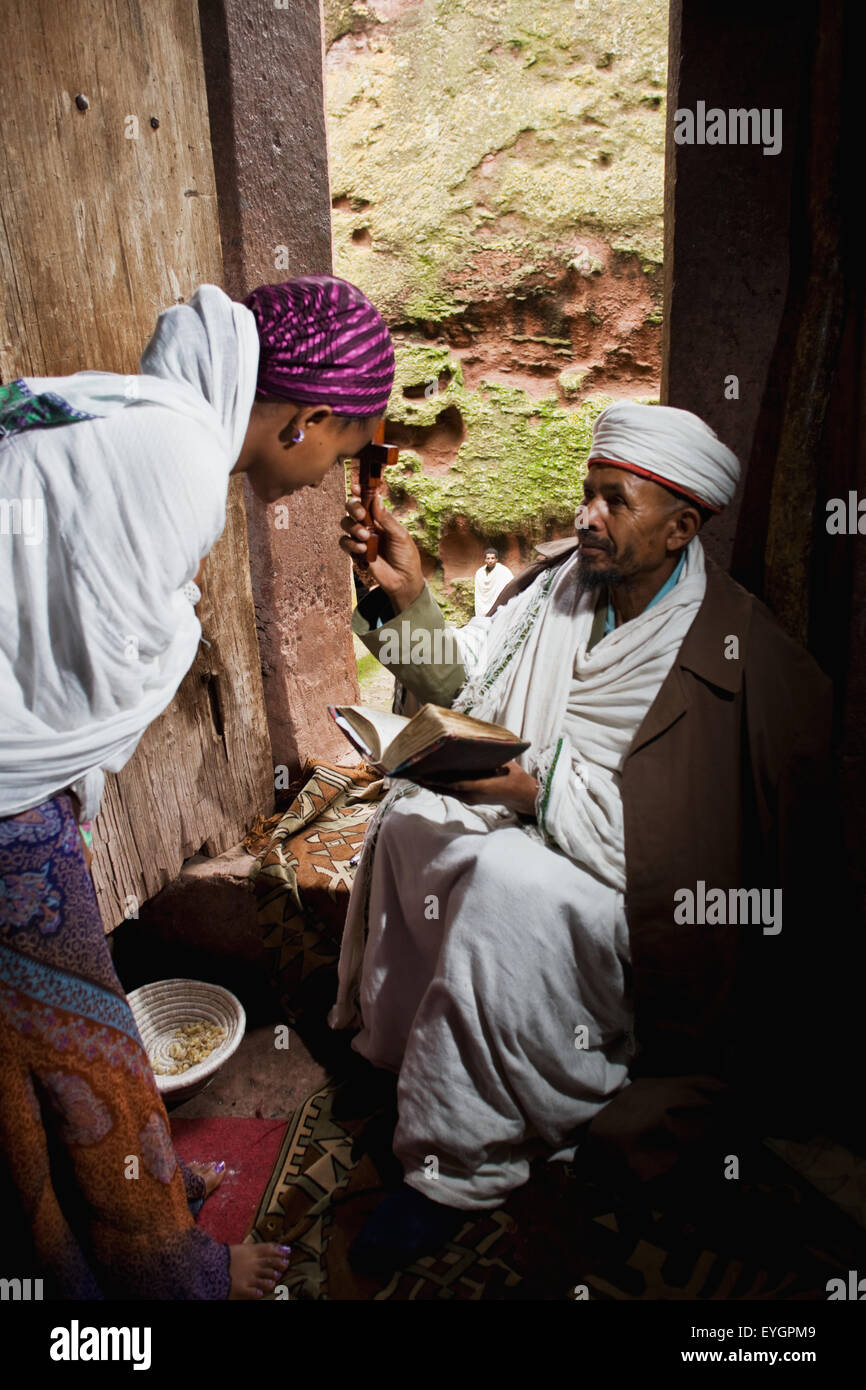 L'Éthiopie, prêtre orthodoxe éthiopienne bénit un pèlerin ; Lalibela Banque D'Images