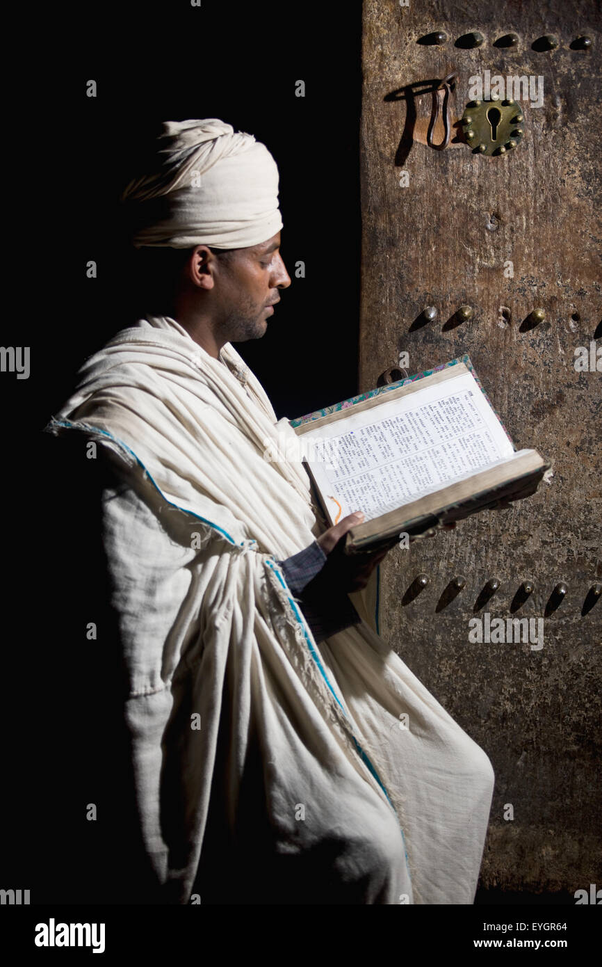 Nord de l'Éthiopie, prêtre orthodoxe éthiopienne la lecture de la bible en Eglise Yemrehanna Krestos ; Lalibela Banque D'Images