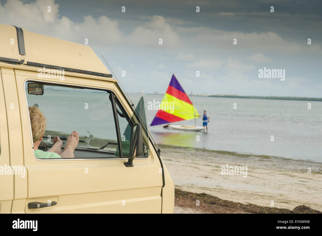 1981 Volkswagen Vanagon Westfalia sur la plage, à l'Dunedin Causeway, en Floride. Regardant un voilier sunfish. Banque D'Images