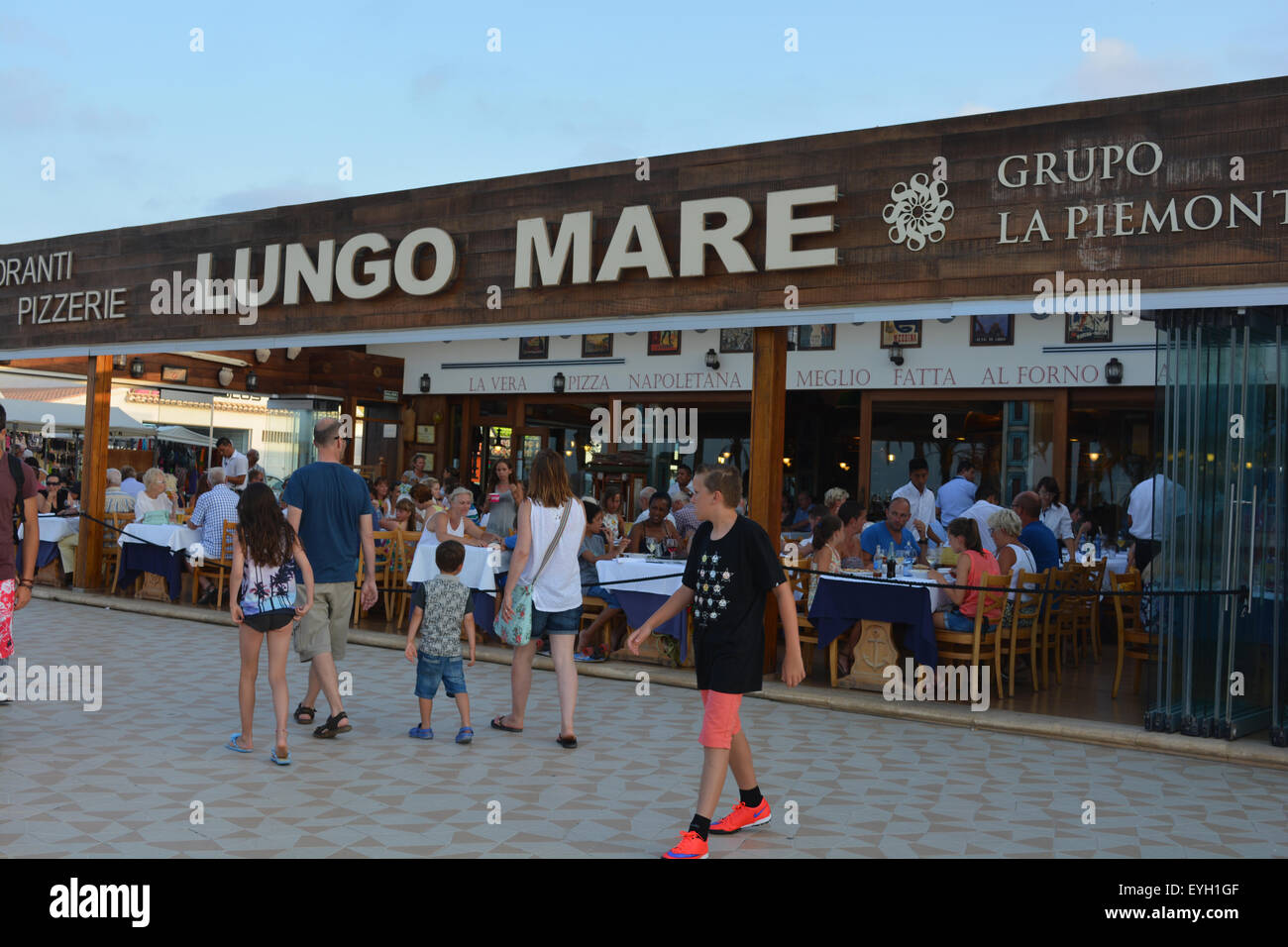 Dernière promenade familiale Restaurant Lungo Mare sur une longue soirée d'été. Le bord de l'Arenal, Javea, Espagne. Banque D'Images